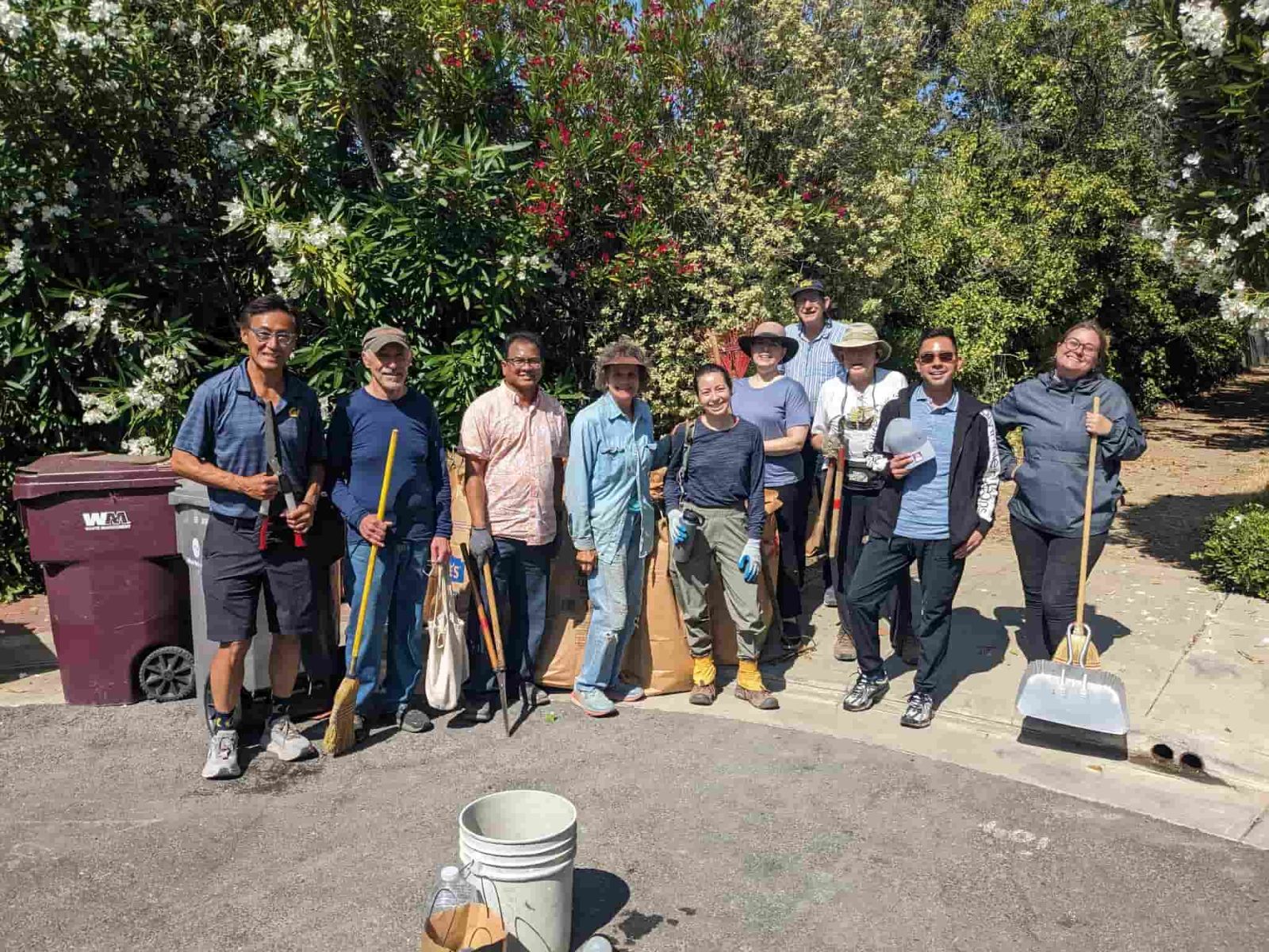 Claremont Club and Spa. Ten volunteers after a workday holding rakes and hand pruners.